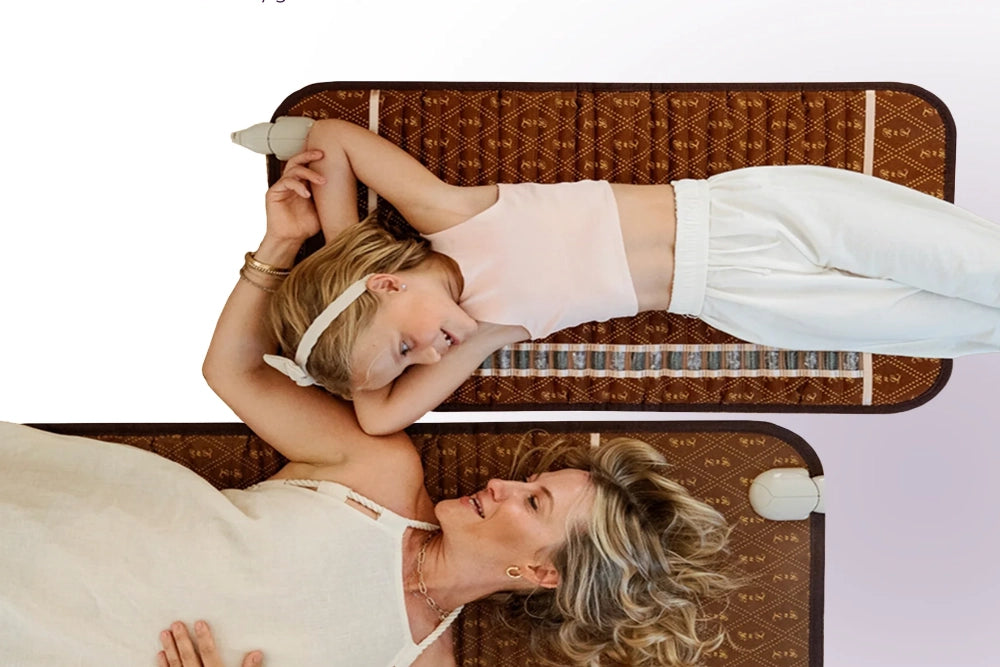 A woman and child lying on BioMat Professional and Mini models