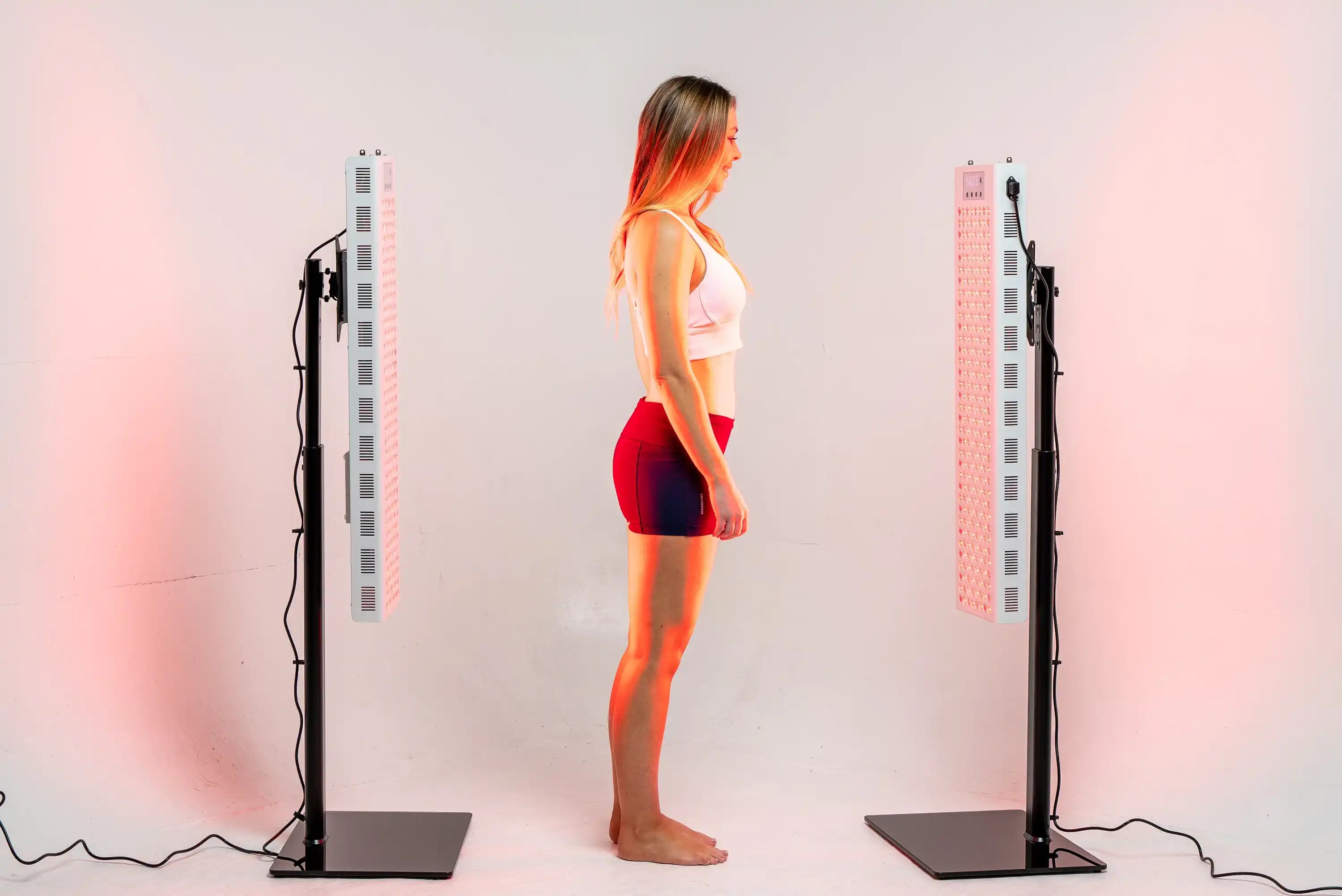 Person standing between two illuminated RedRush 840 PULSE panels